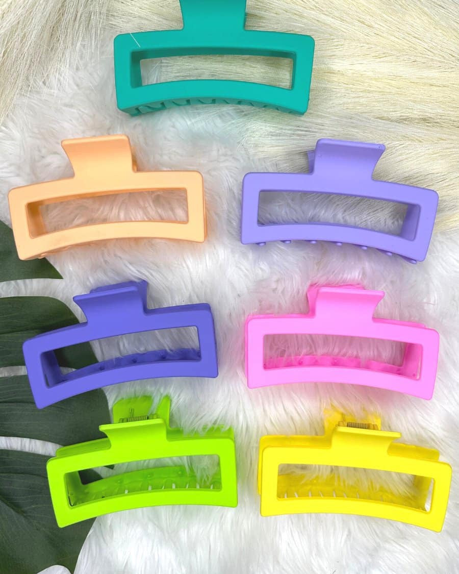 Set of colorful hair clips on a textured surface