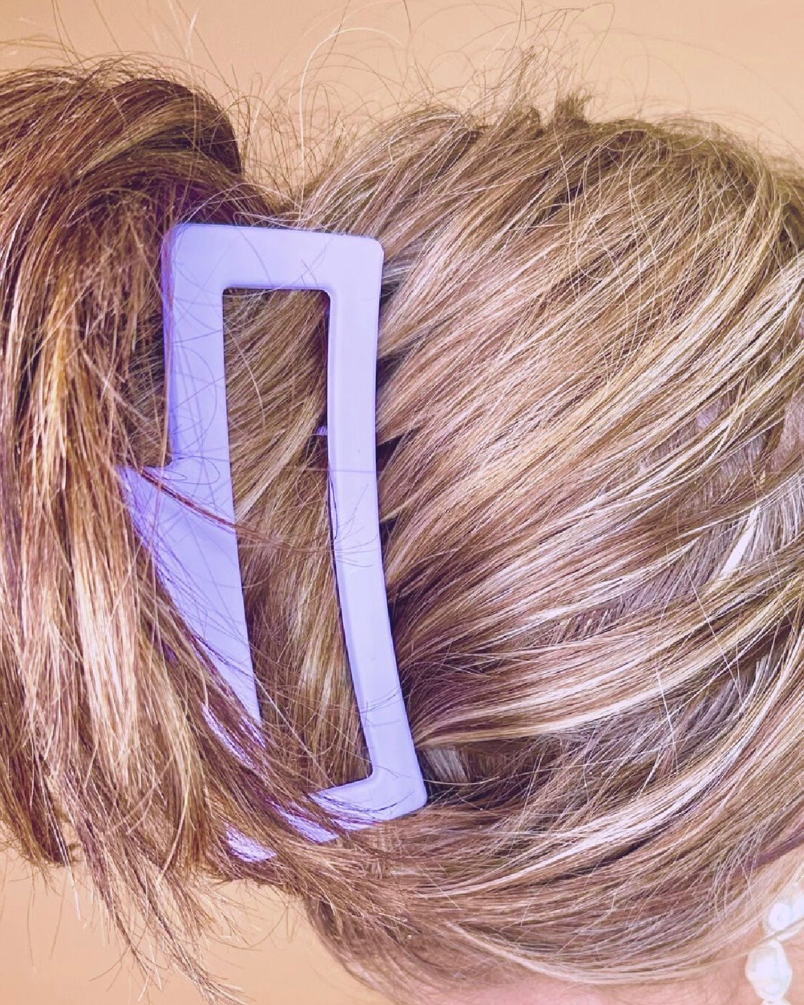 Close-up of a person's hair with a lavender hair clip.