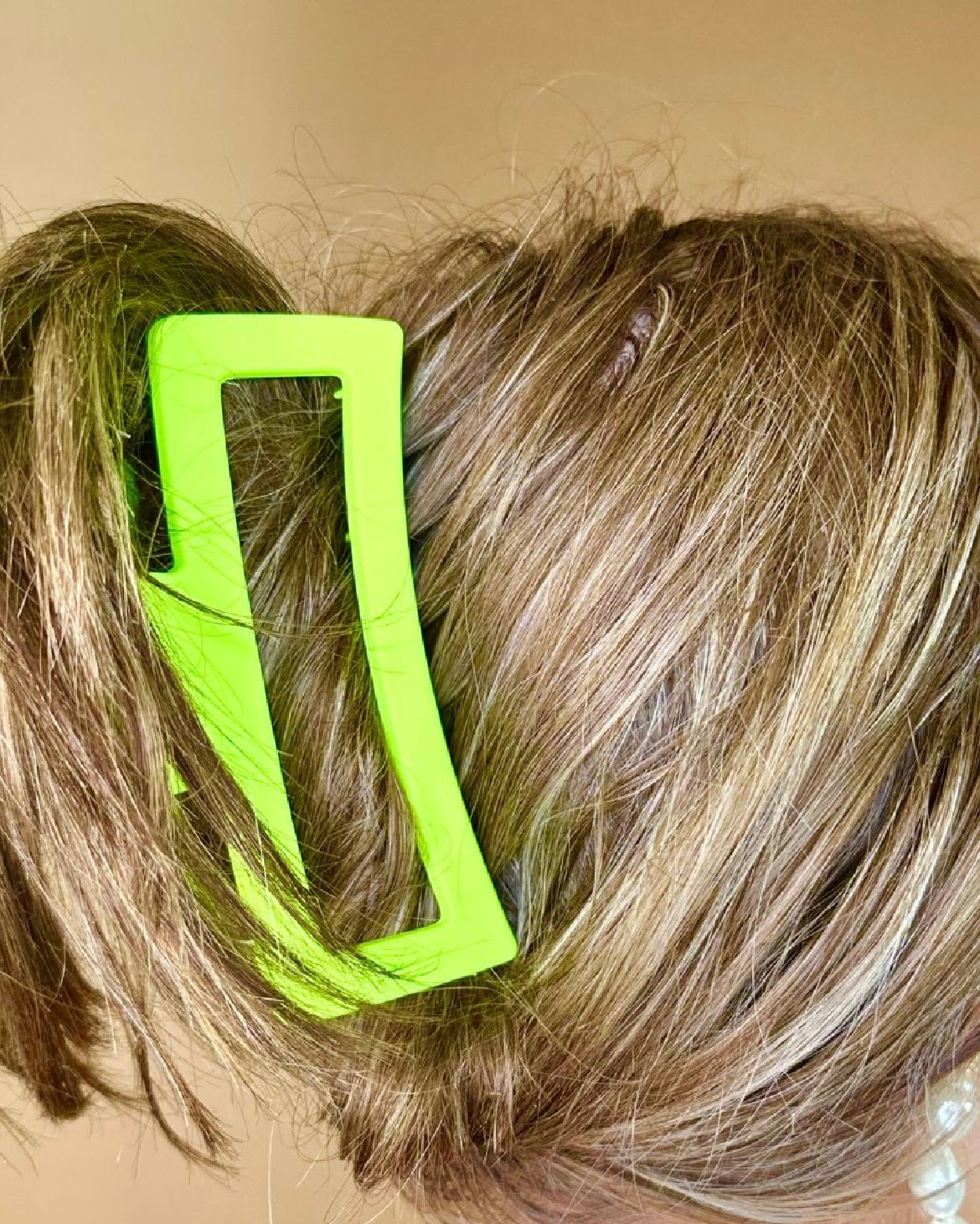 Close-up of a person's hair with a lime hair clip.