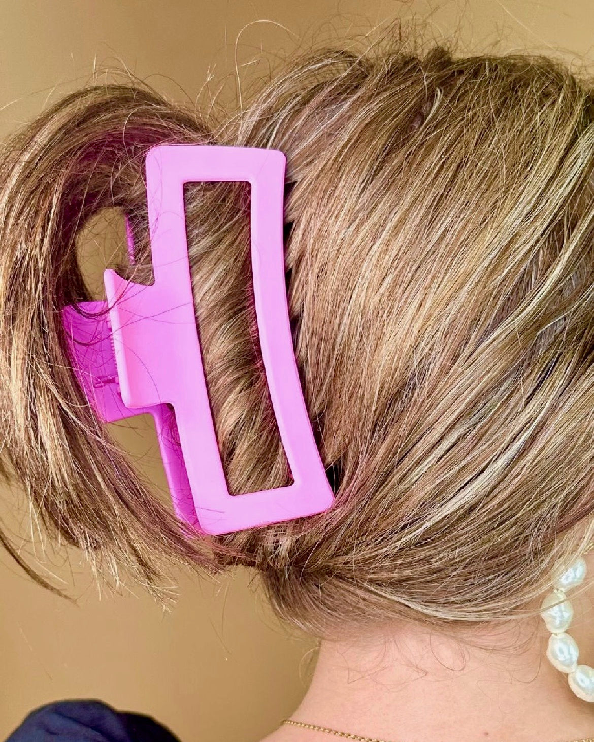 Close-up of a person's hair with a pink hair clip.