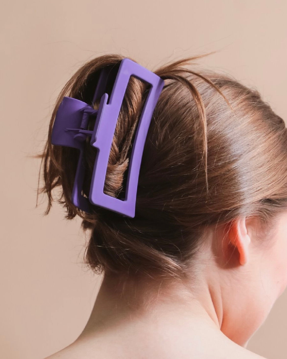 Close-up of a person's hair with a purple hair clip.