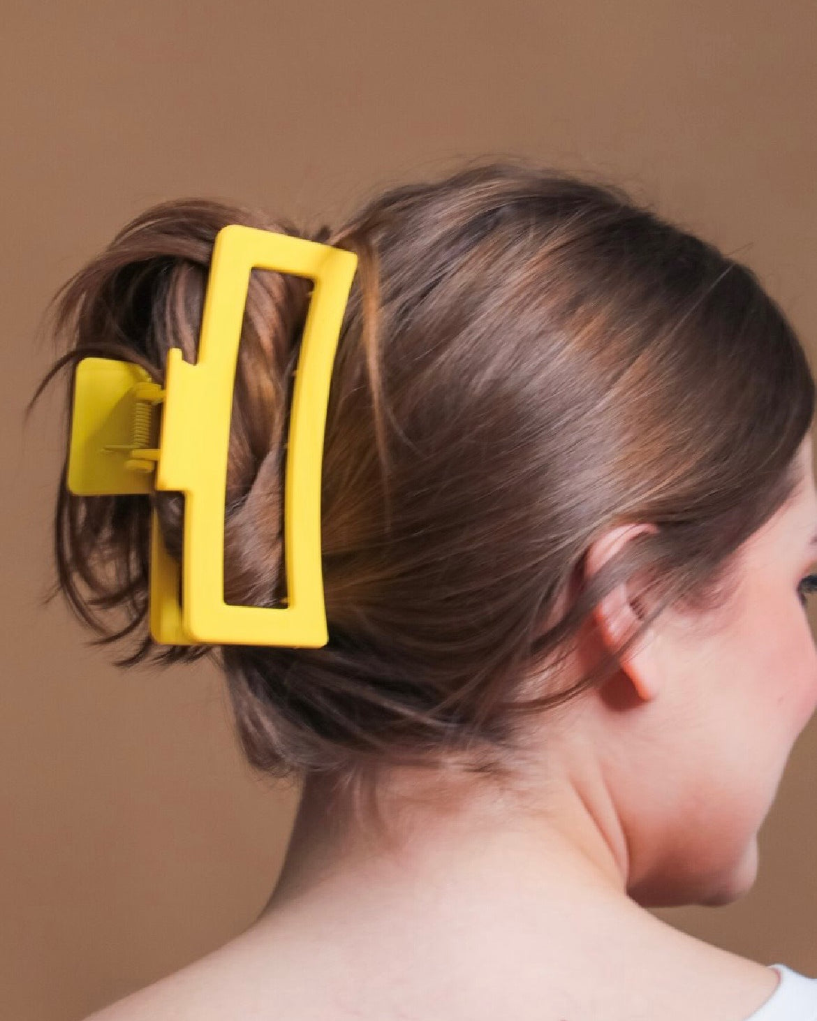 Close-up of a person's hair with a yellow hair clip.