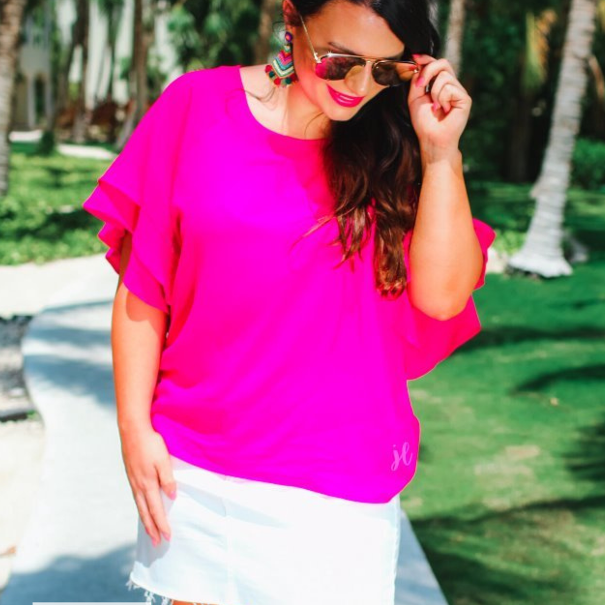 a pink true-to-size blouse crafted from lightweight textured fabric with a rounded neckline, tiered ruffle sleeves, and a relaxed drape, accented by a MADE IN USA watermark in the bottom left-hand corner