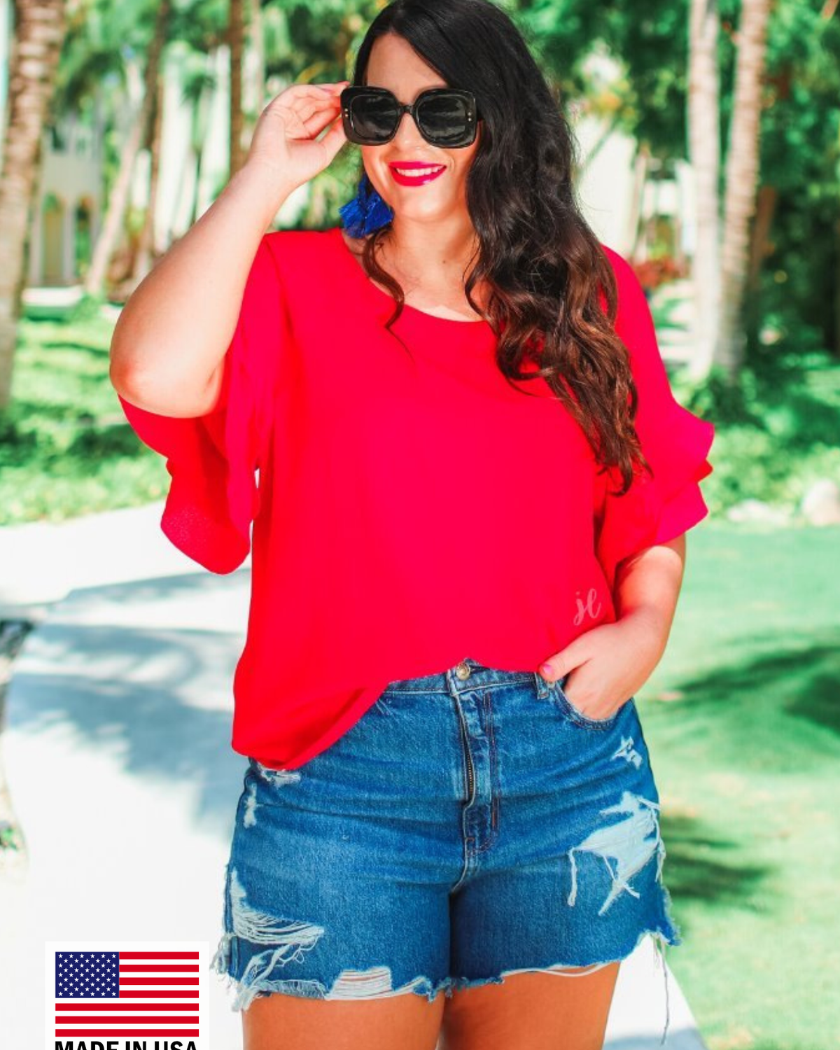a red true-to-size blouse crafted from lightweight textured fabric with a rounded neckline, tiered ruffle sleeves, and a relaxed drape, accented by a MADE IN USA watermark in the bottom left-hand corner