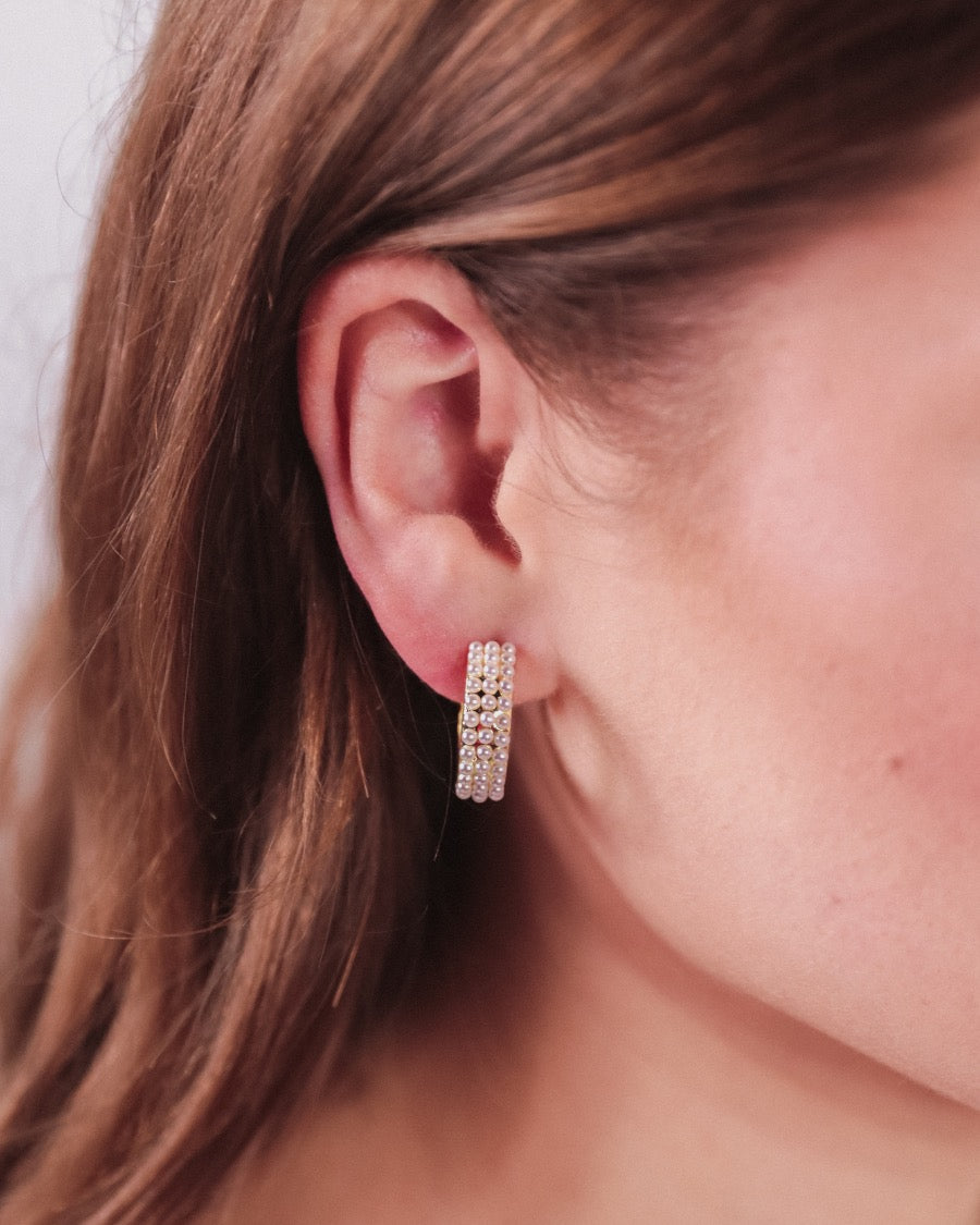 gold-plated hoop stud earring with three rows of delicate pearls, a comfort back earring, and a plastic disc stopper in gold