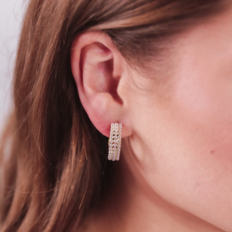 gold-plated hoop stud earring with three rows of delicate pearls, a comfort back earring, and a plastic disc stopper in gold