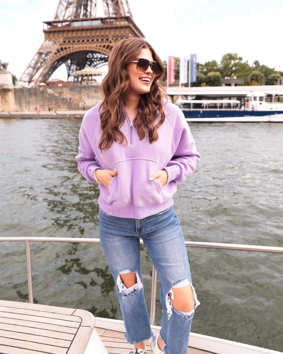 a cropped hooded quarter zip pullover with a relaxed fit, functional kangaroo pocket, and thumb holes in lavender