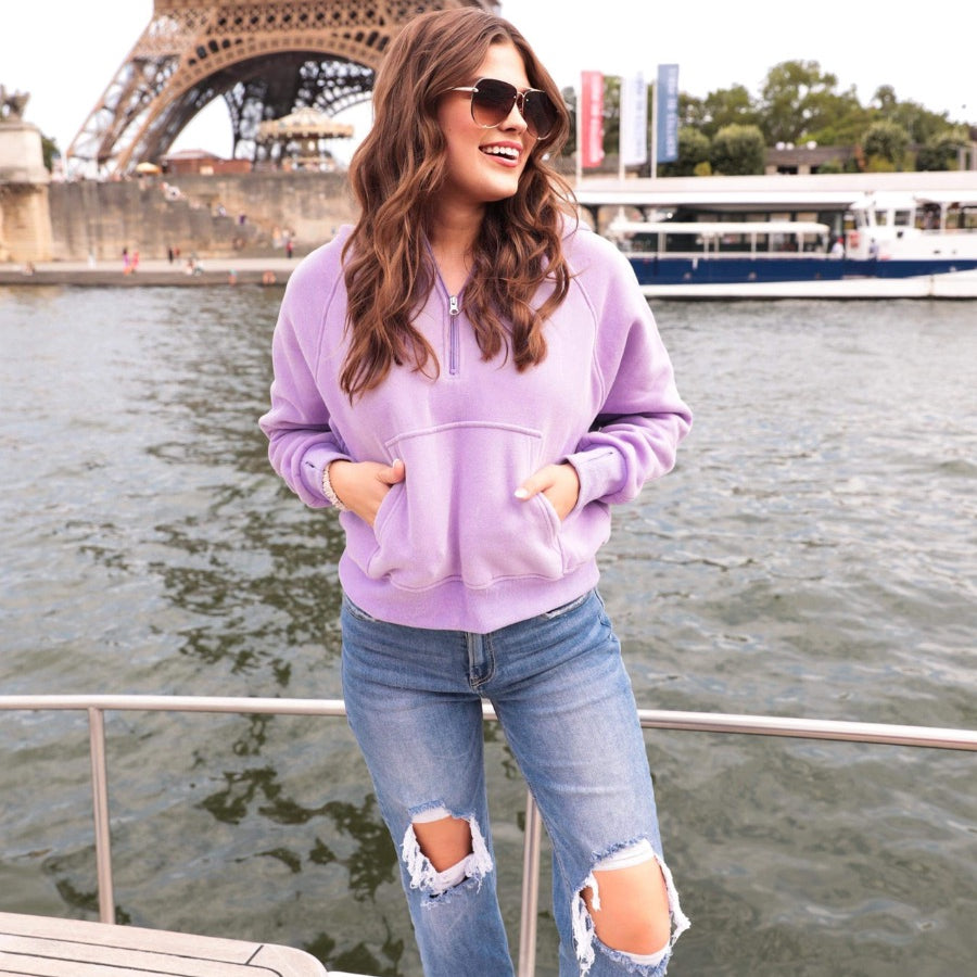 a cropped hooded quarter zip pullover with a relaxed fit, functional kangaroo pocket, and thumb holes in lavender