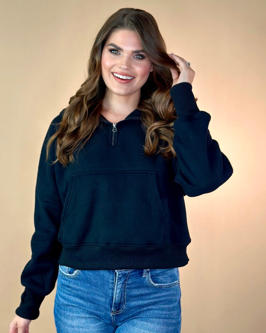 a cropped hooded quarter zip pullover with a relaxed fit, functional kangaroo pocket, and thumb holes in black