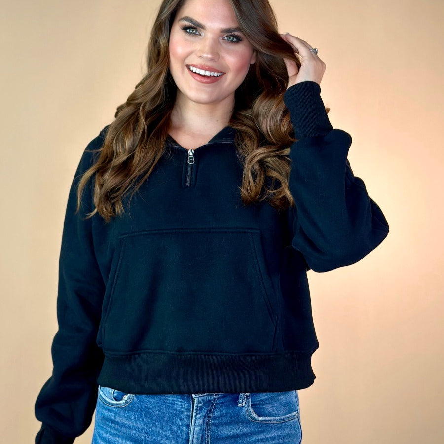 a cropped hooded quarter zip pullover with a relaxed fit, functional kangaroo pocket, and thumb holes in black