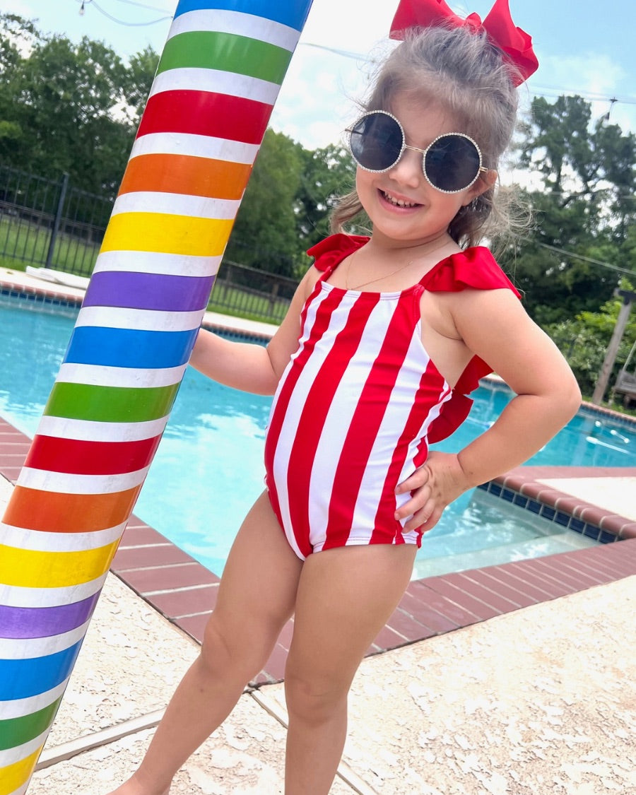 kids' sunglasses with rose gold frame and bridge, black round lenses, rhinestone trim, black temple tips featuring the brand name in white, nose pads, UV protection, and a signature pouch