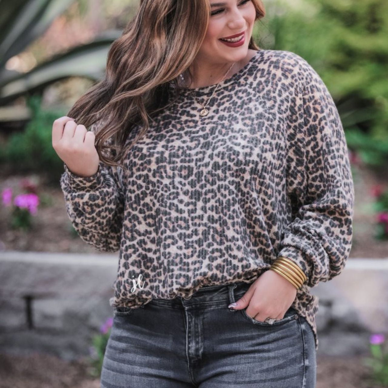 MADE IN USA long-sleeve top crafted from soft material with a waffle knit texturing, a round neckline, and a relaxed silhouette that falls into a split hi low rounded hemline on a black leopard pattern fabric and a tan base
