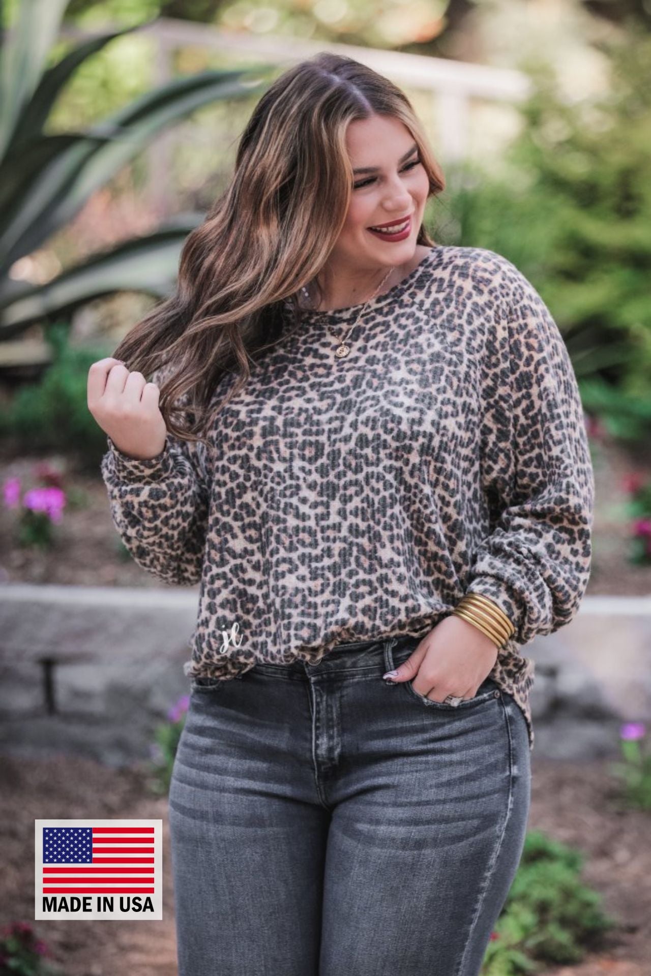 MADE IN USA long-sleeve top crafted from soft material with a waffle knit texturing, a round neckline, and a relaxed silhouette that falls into a split hi low rounded hemline on a black leopard pattern fabric and a tan base