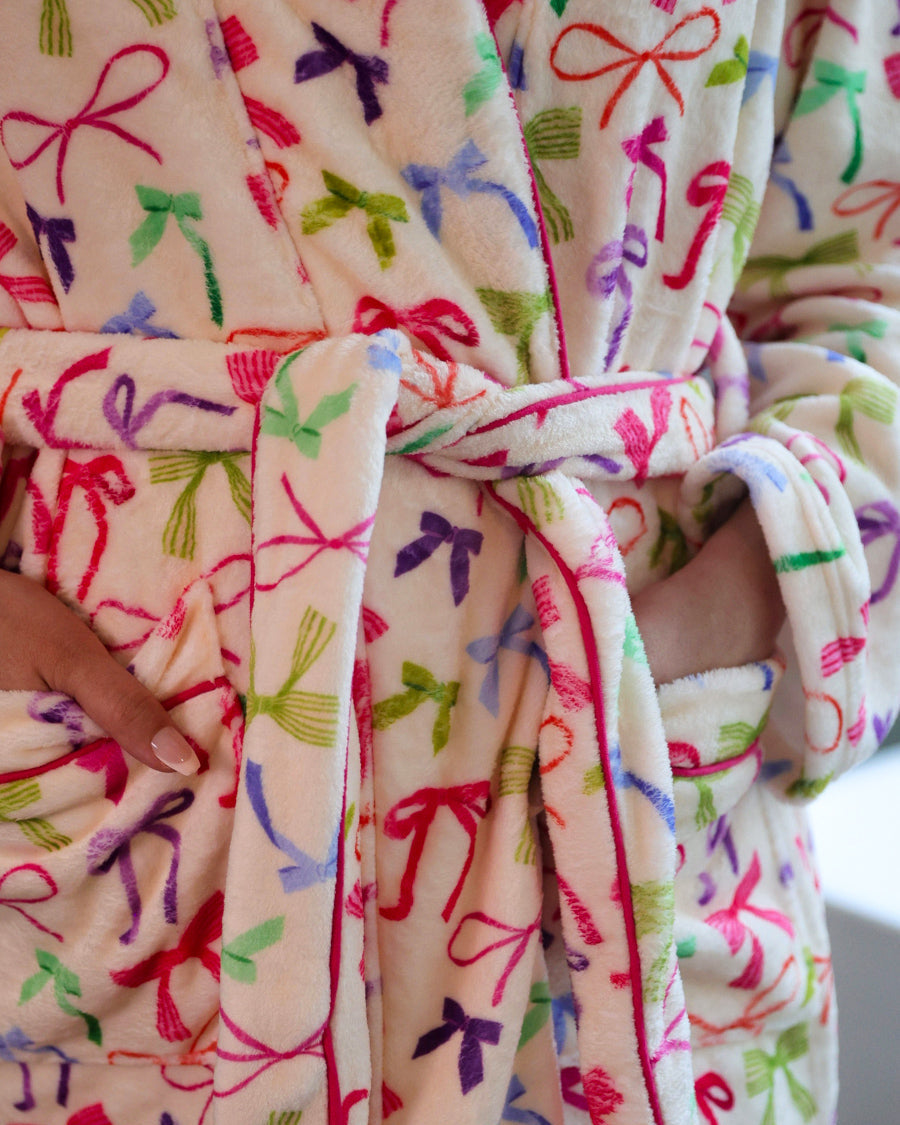 a long sleeve robe with a flattering wrap silhouette, an adjustable waist tie, a playful ruffle hem, and deep patch pockets on ultra plush fabric in Daylight Bow (Multi)