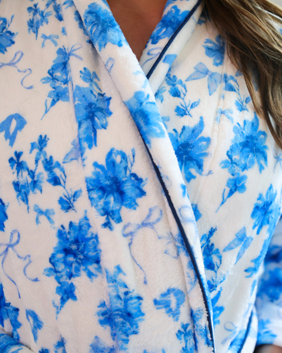 a long sleeve robe with a flattering wrap silhouette, an adjustable waist tie, a playful ruffle hem, and deep patch pockets on ultra plush fabric in Blue Blossom (Blue)