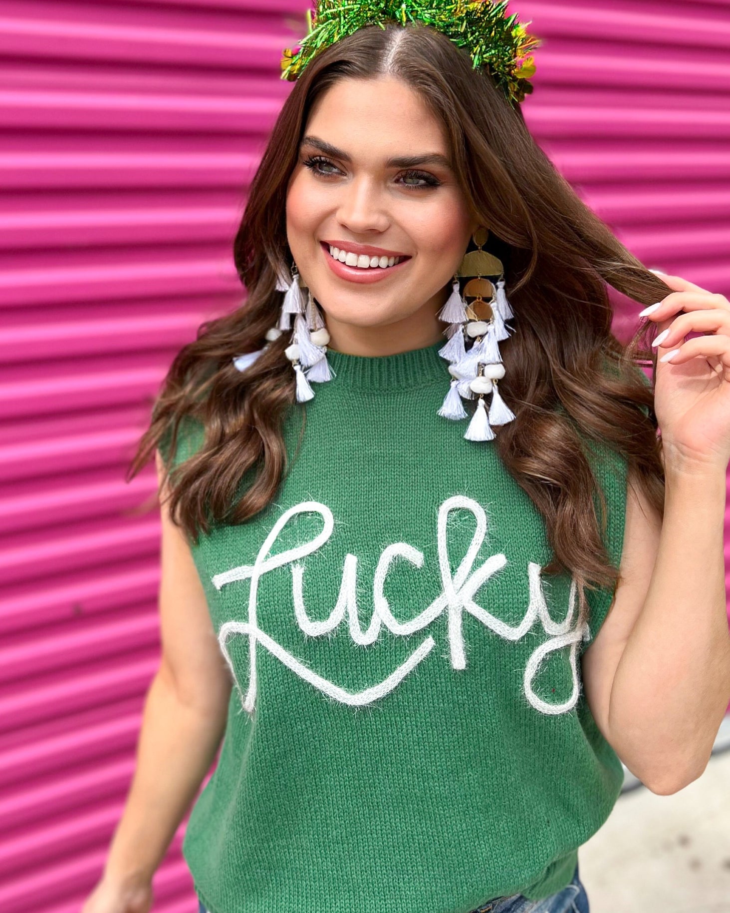 a green soft knit sleeveless seater vest with shimmering 'Lucky' lettering, a relaxed fit, and ribbed collar, cuffs, and hem