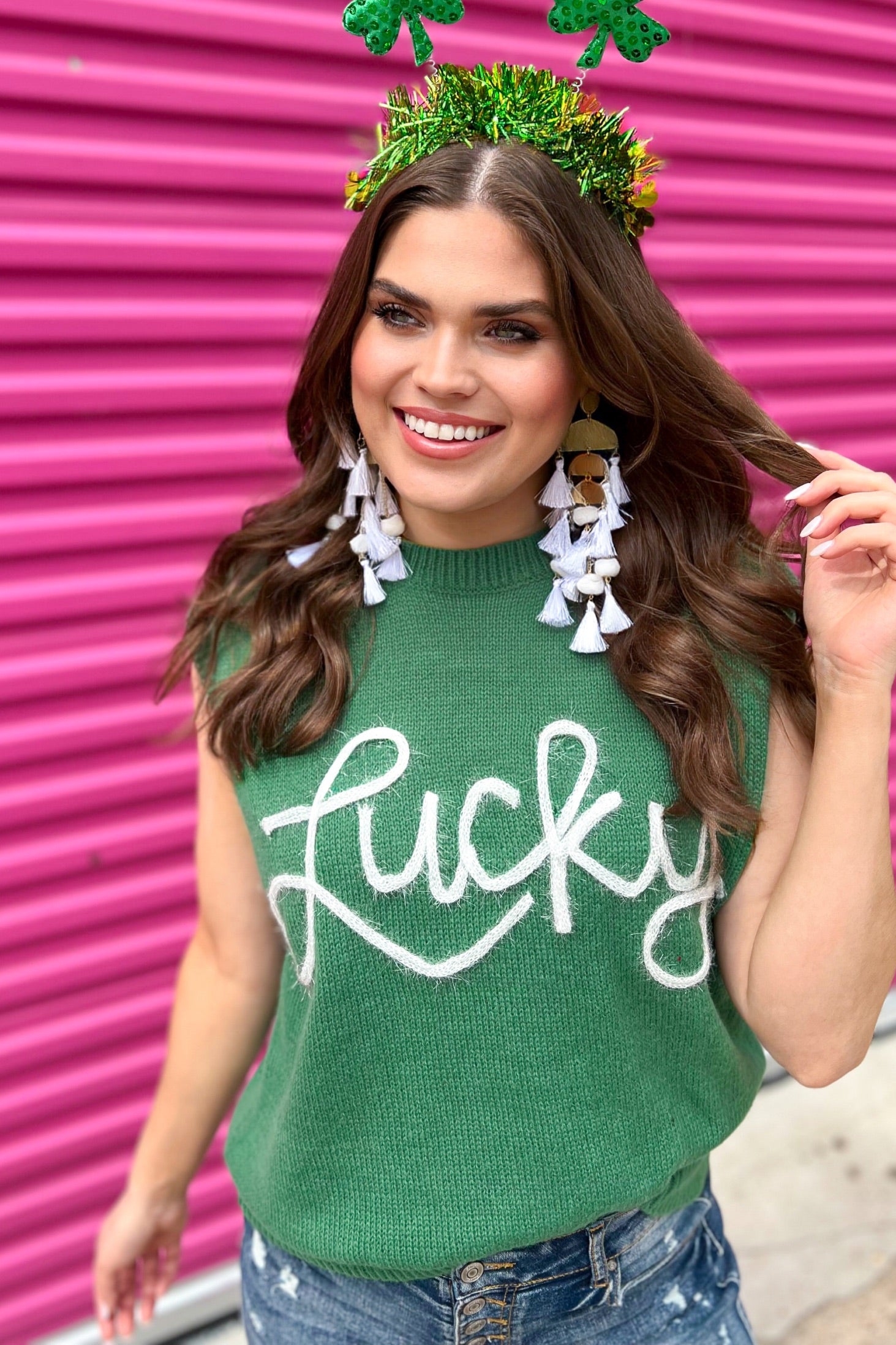 a green soft knit sleeveless seater vest with shimmering 'Lucky' lettering, a relaxed fit, and ribbed collar, cuffs, and hem