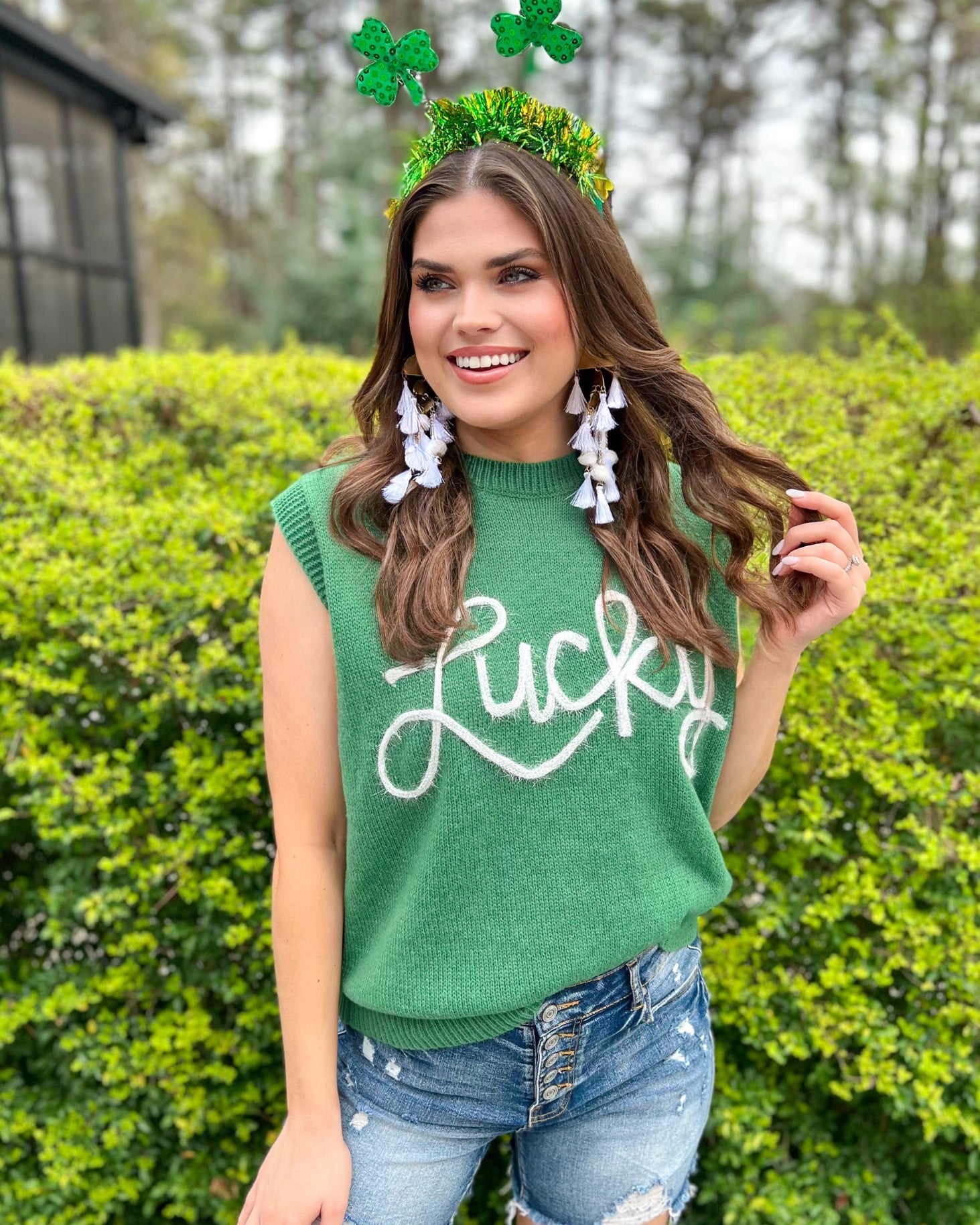 a green soft knit sleeveless seater vest with shimmering 'Lucky' lettering, a relaxed fit, and ribbed collar, cuffs, and hem