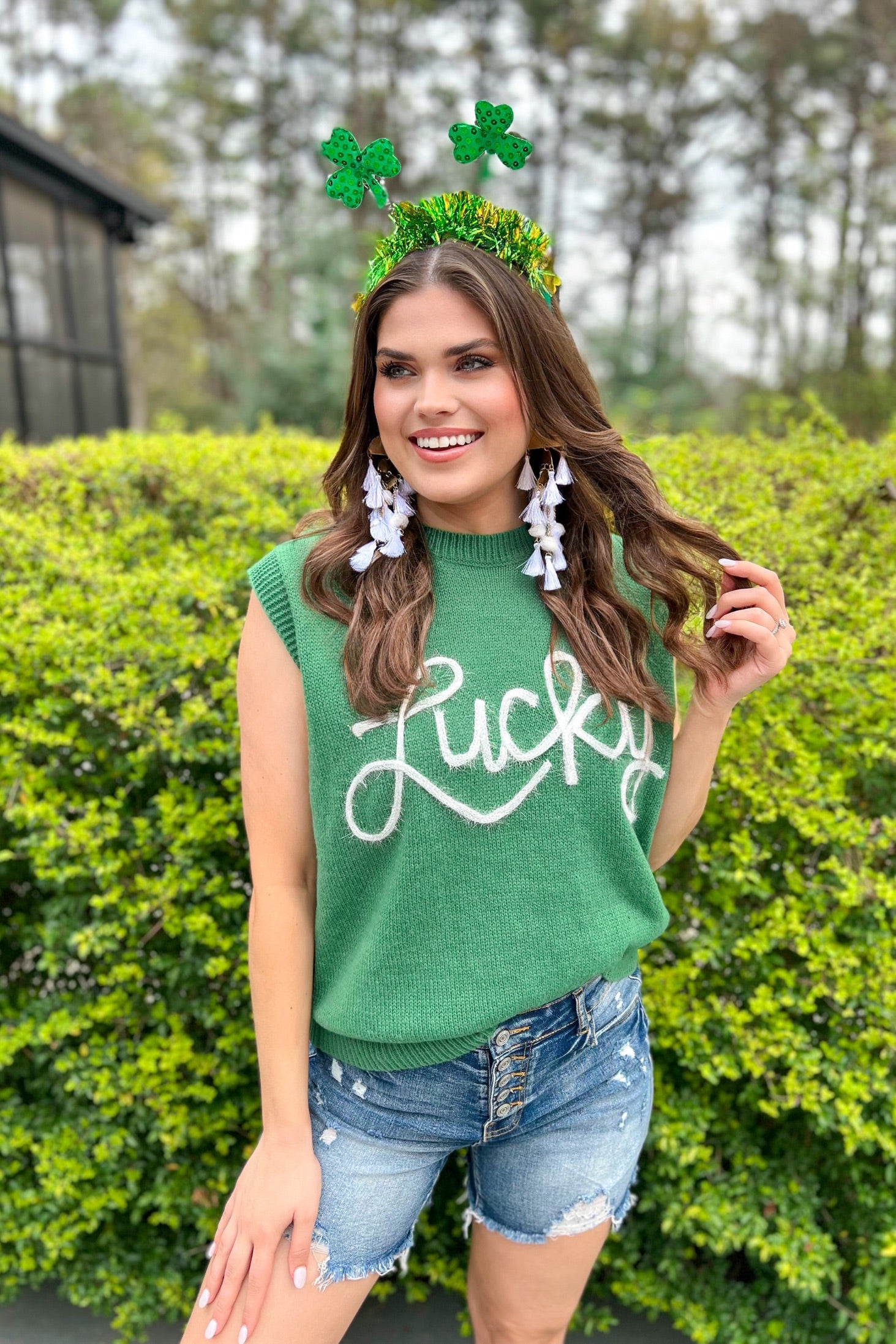 a green soft knit sleeveless seater vest with shimmering 'Lucky' lettering, a relaxed fit, and ribbed collar, cuffs, and hem
