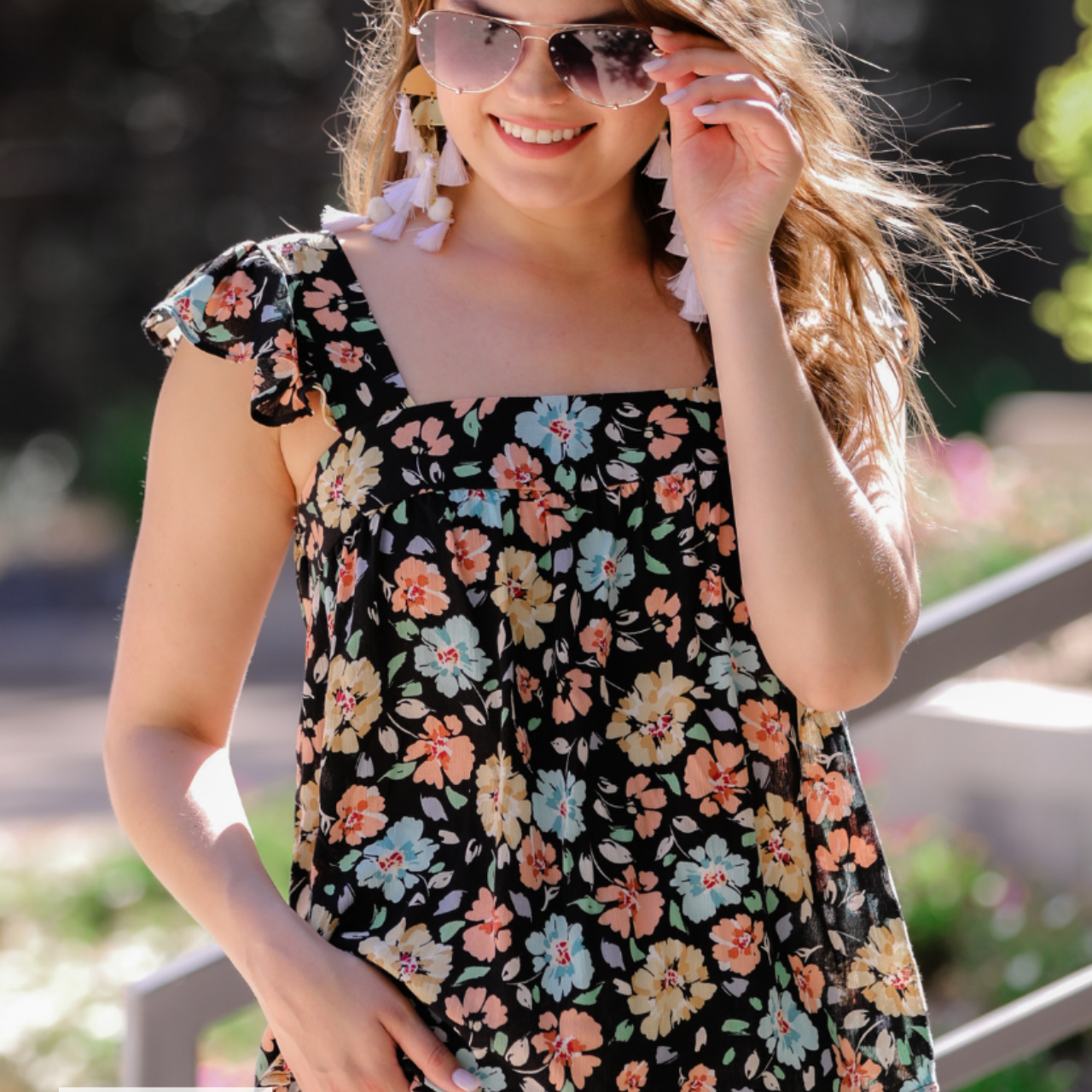 MADE IN USA a sleeveless tank with a squared neckline, ruffle tank sleeves, and a flowy body on a floral pattern and black base