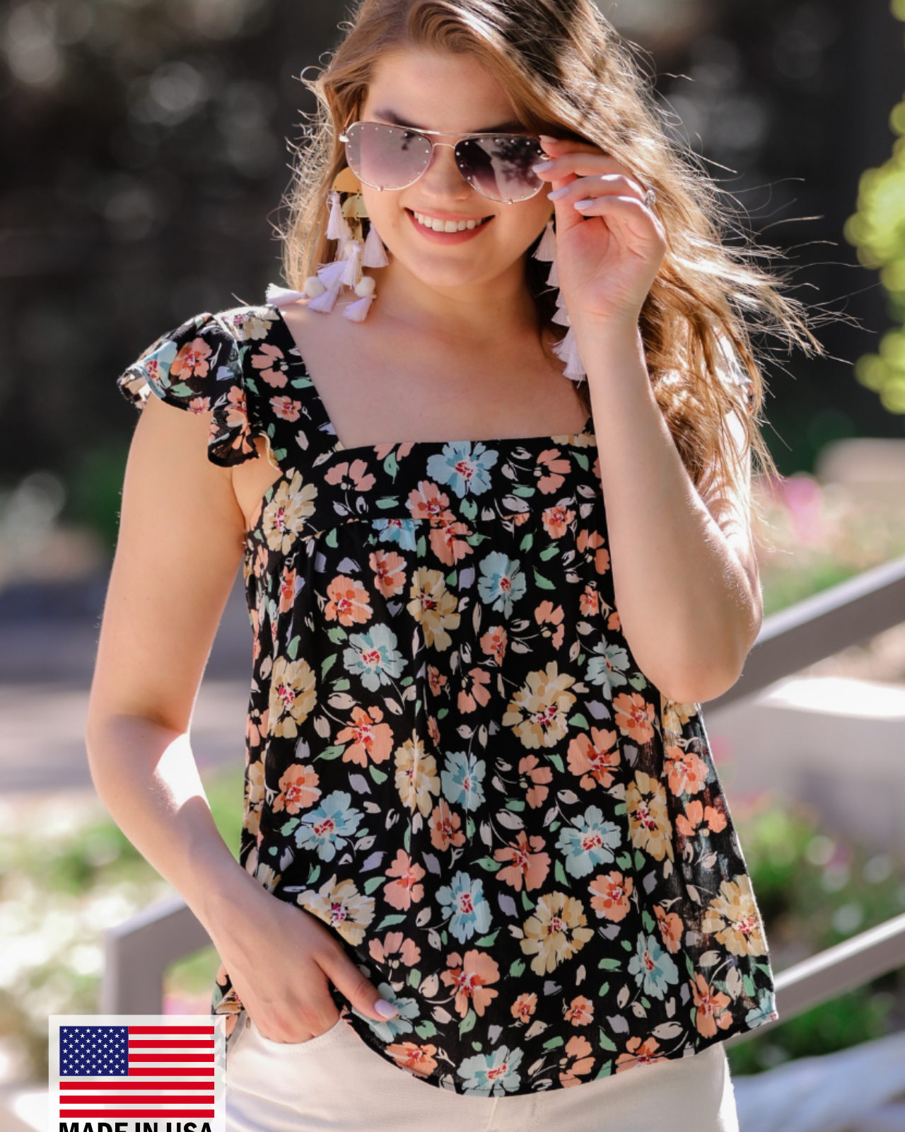 MADE IN USA a sleeveless tank with a squared neckline, ruffle tank sleeves, and a flowy body on a floral pattern and black base