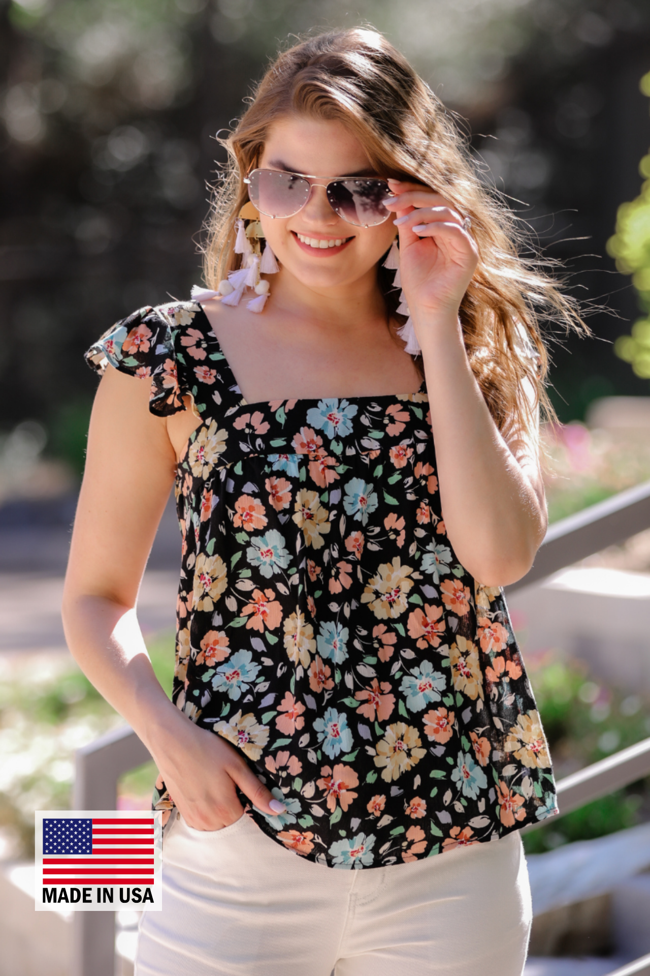 MADE IN USA a sleeveless tank with a squared neckline, ruffle tank sleeves, and a flowy body on a floral pattern and black base