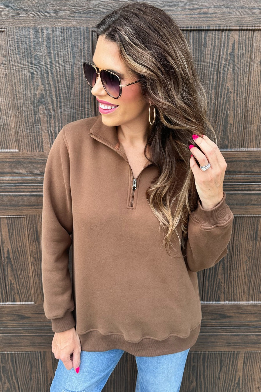 a long-sleeve pullover made of cozy fabric with a quarter zip, cuffs, and a split waistband hem in brown