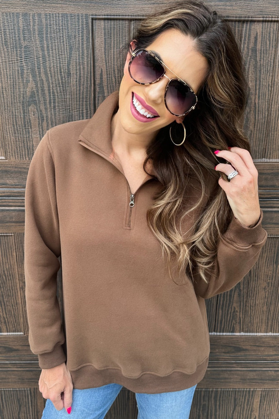 a long-sleeve pullover made of cozy fabric with a quarter zip, cuffs, and a split waistband hem in brown