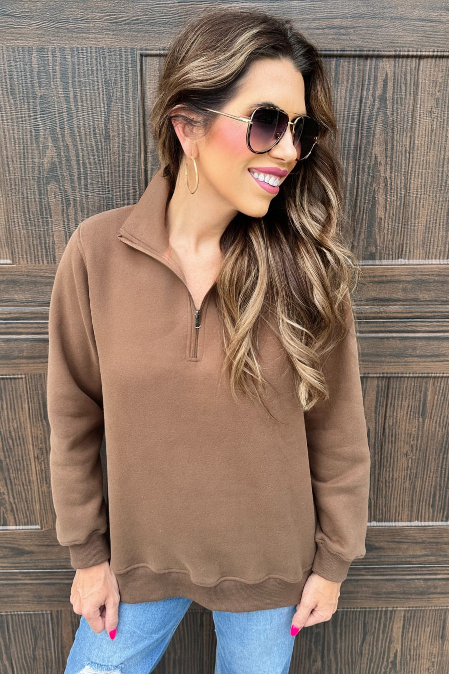 a long-sleeve pullover made of cozy fabric with a quarter zip, cuffs, and a split waistband hem in brown