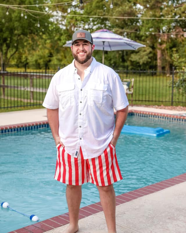 red and white vertical stripe swim trunks with an elastic waistband, drawstring tie, pockets, and built-in mesh underwear