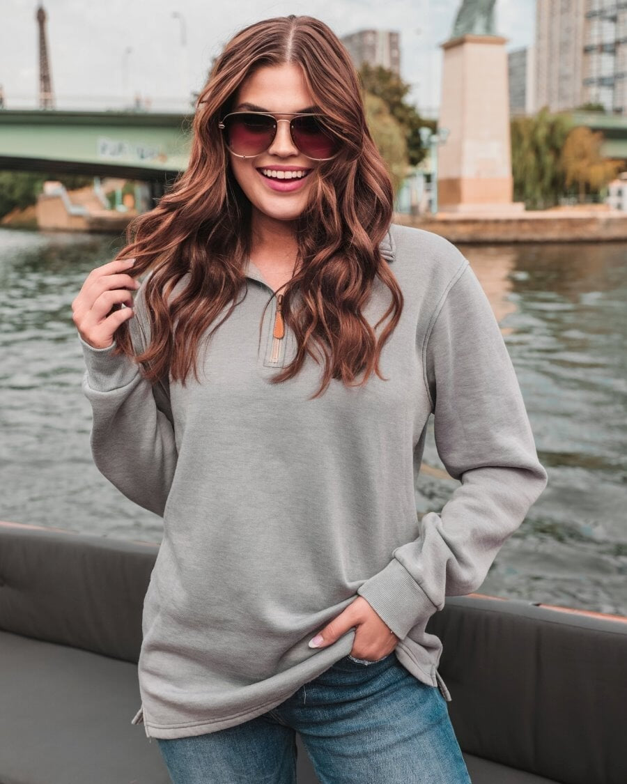 long sleeve pullover crafted from vintage wash fabric with a foldable collar, side slits, and a quarter zip in grey