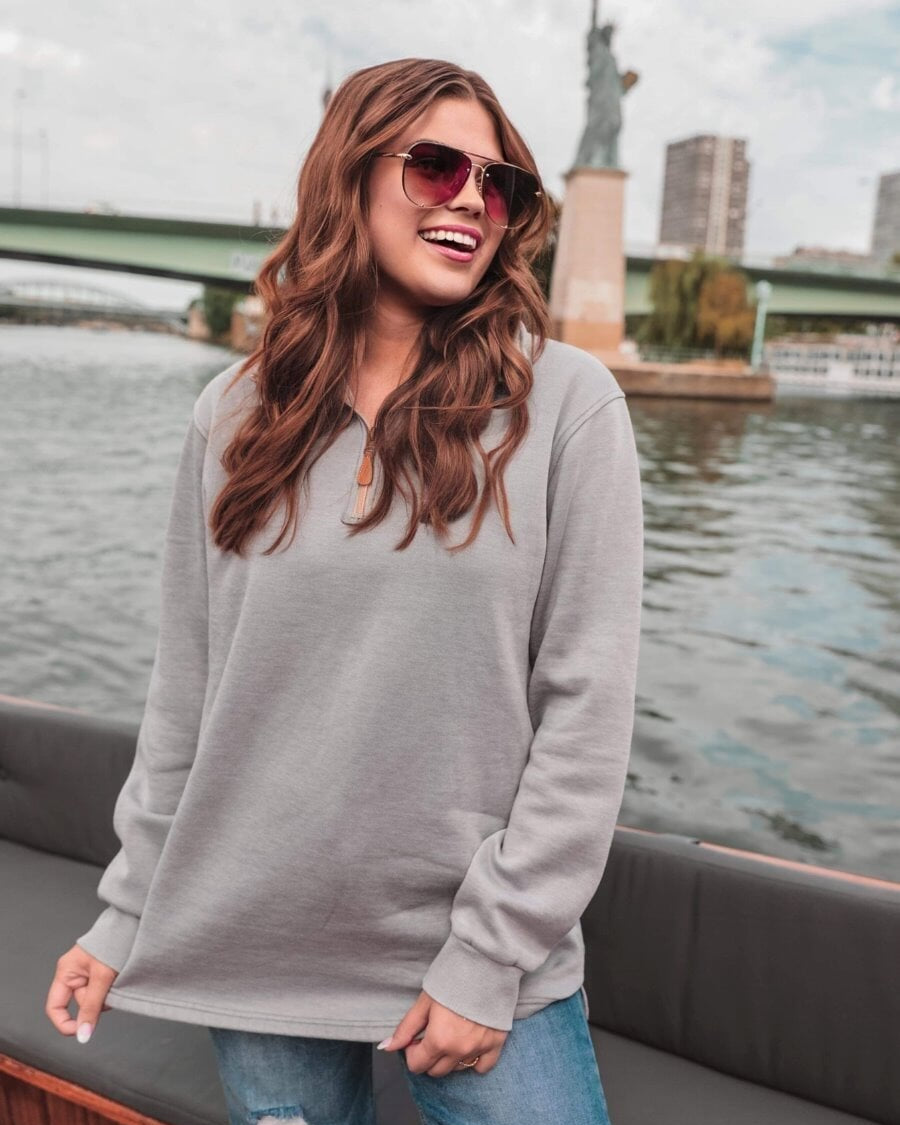 long sleeve pullover crafted from vintage wash fabric with a foldable collar, side slits, and a quarter zip in grey