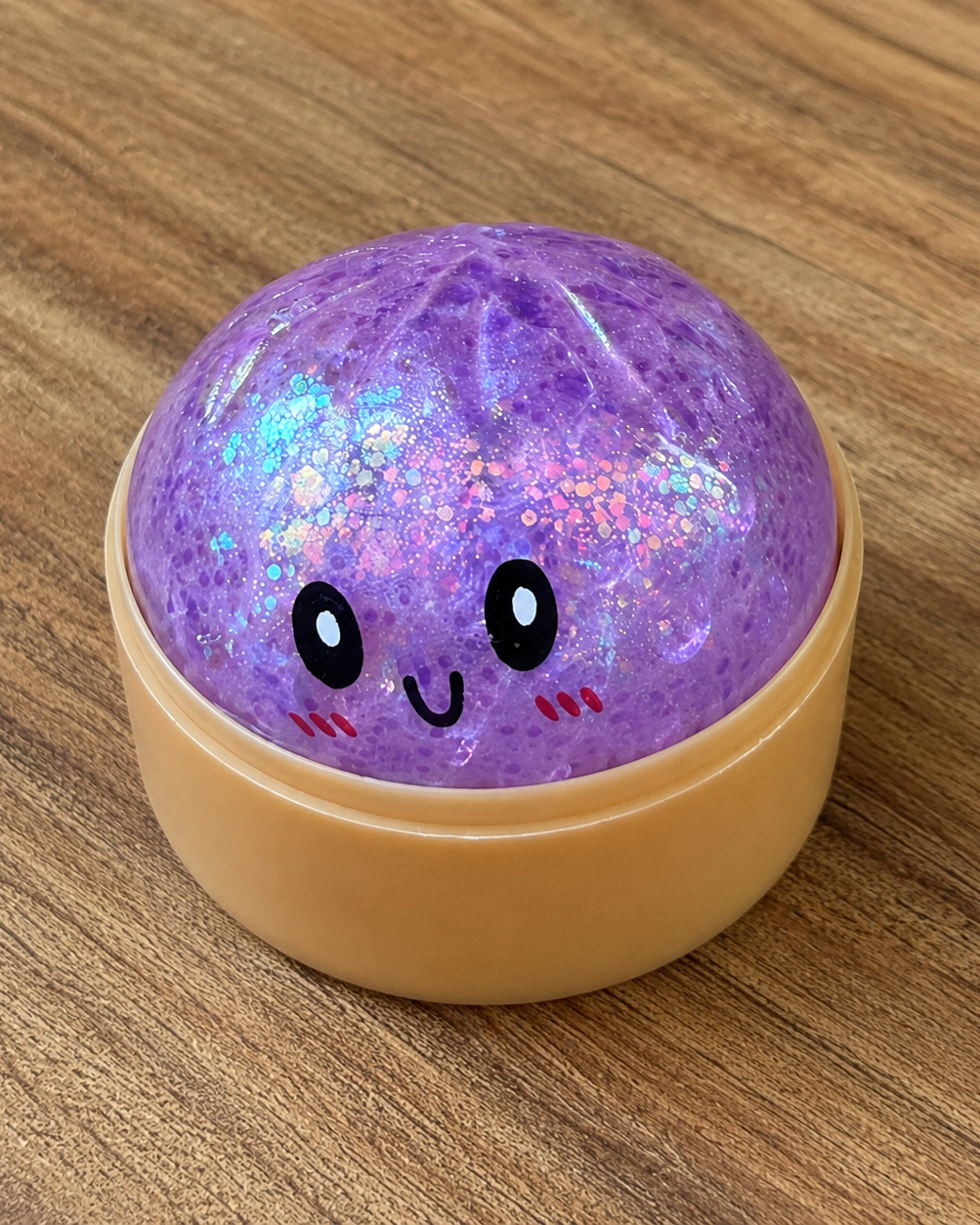 a purple mystery bead-filled mini dumpling squishy with assorted colors, iridescent shimmer, kawaii face, steamer-style container, and soft sensory texture