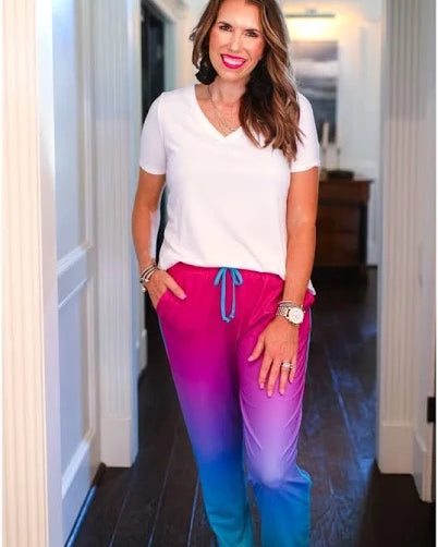 relaxed fit mid-rise joggers with side pockets and a tie waist drawstring, designed on a magenta to turquoise ombré print fabric with turquoise trim