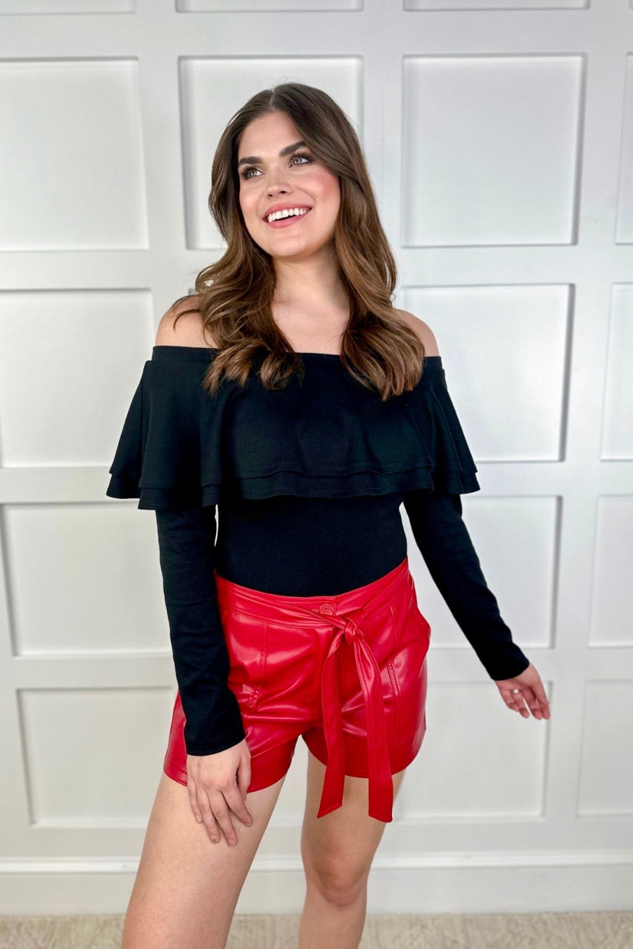 sleek faux leather shorts with zip and button closure, side pockets, a non-removable tie detail, and an elastic back waistband in red