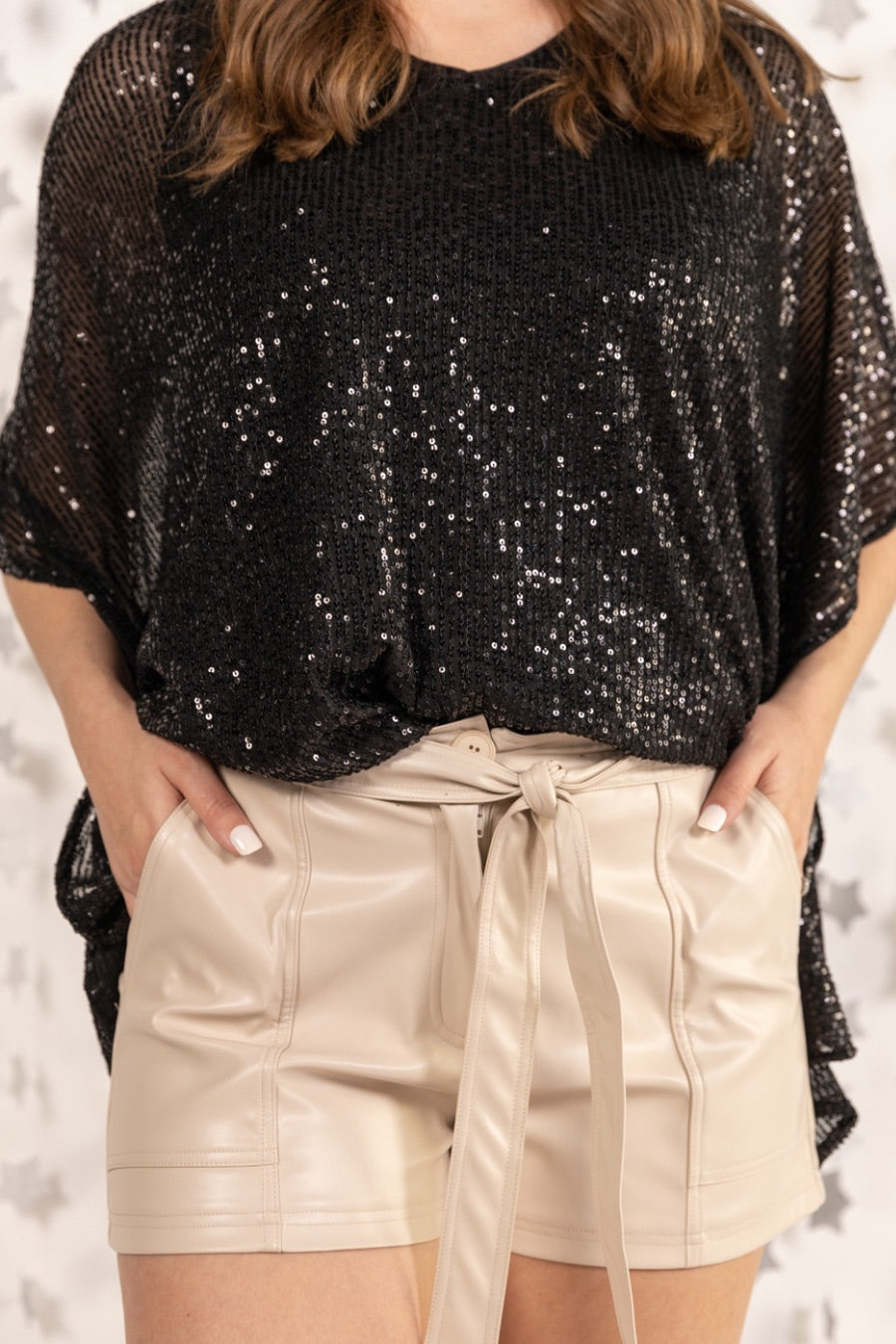 sleek faux leather shorts with zip and button closure, side pockets, a non-removable tie detail, and an elastic back waistband in taupe