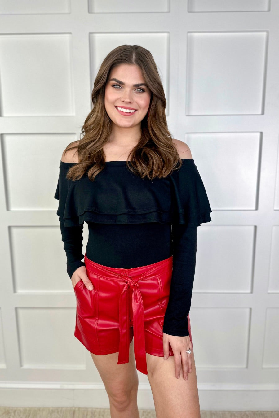 sleek faux leather shorts with zip and button closure, side pockets, a non-removable tie detail, and an elastic back waistband in red