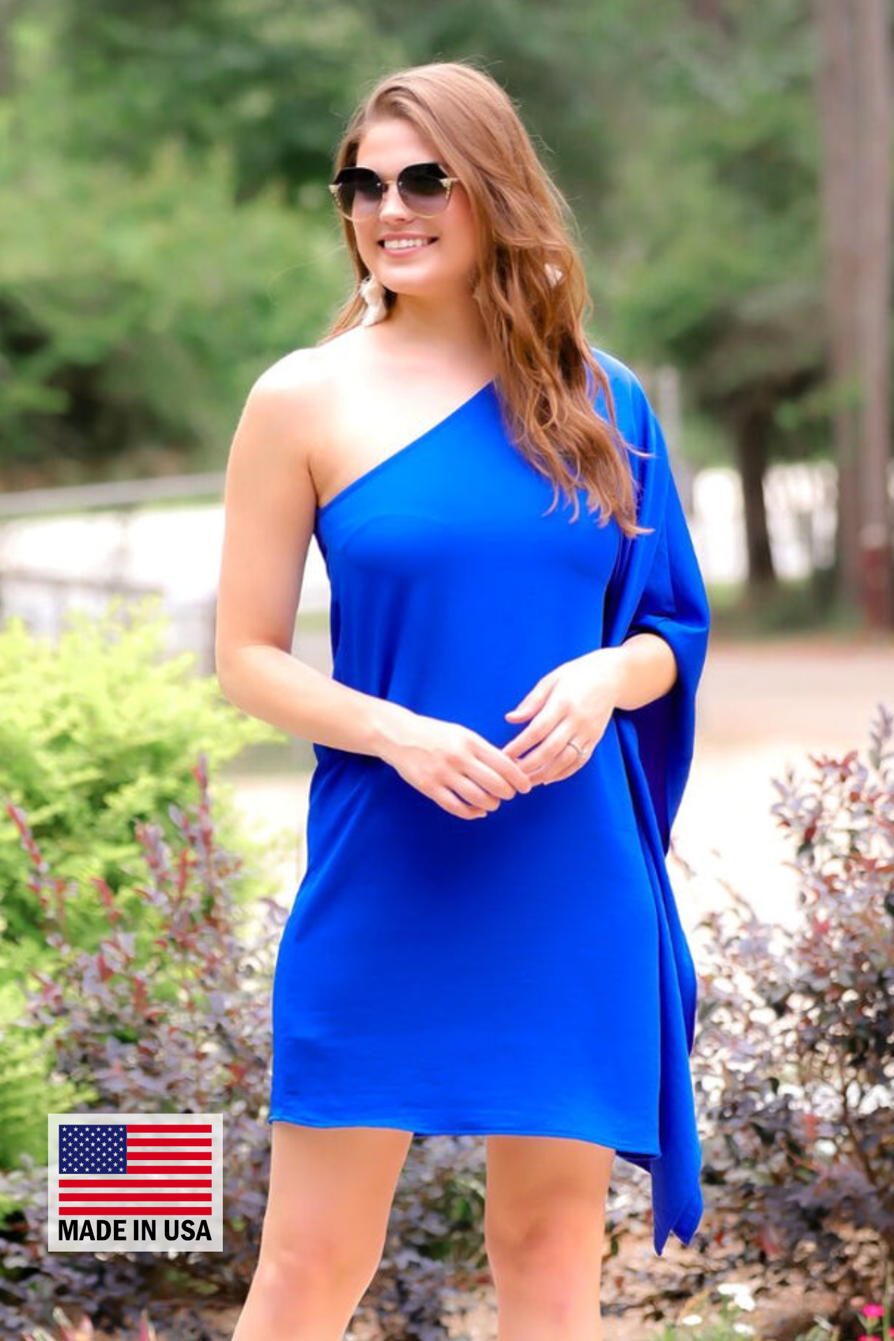 a royal blue one-shoulder mini dress with an asymmetrical neckline and a draping, billowy body creating a relaxed silhouette with a MADE IN USA watermark in bottom lefthand corner