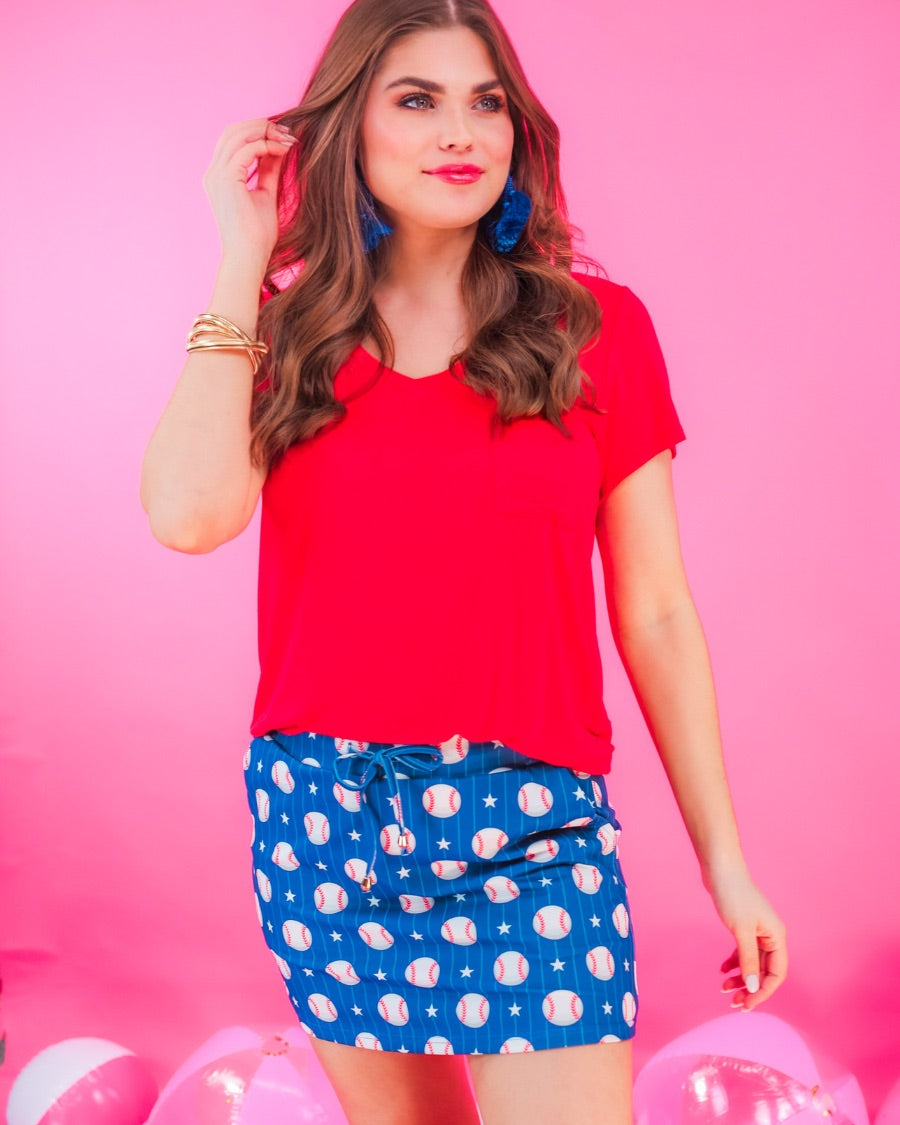 mid-relaxed fit everyday skort made of lightweight material with built-in ivory shorts, drawstring tie, an elastic band on the back, and side pockets, designed on a baseball pattern print and royal blue base