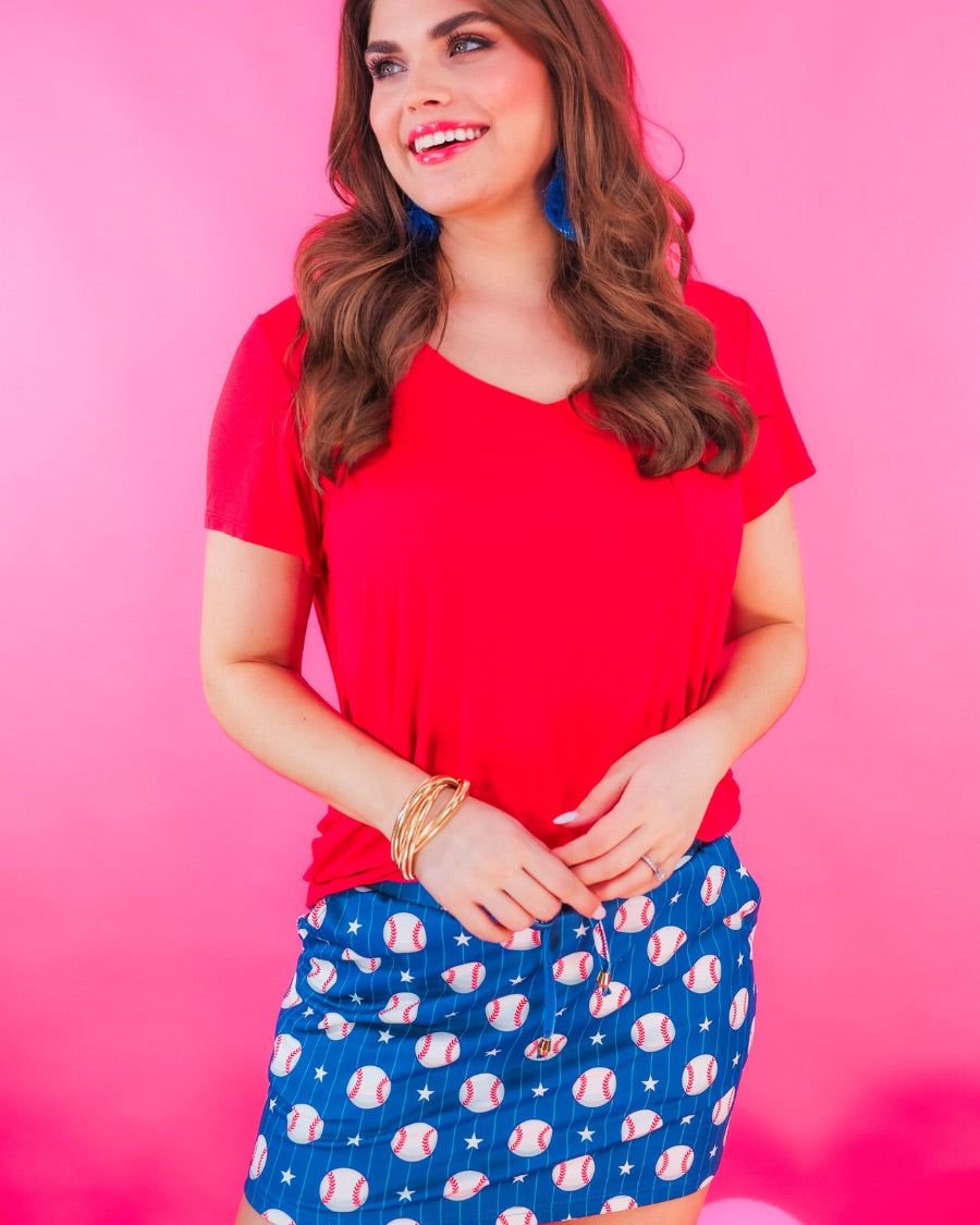 mid-relaxed fit everyday skort made of lightweight material with built-in ivory shorts, drawstring tie, an elastic band on the back, and side pockets, designed on a baseball pattern print and royal blue base