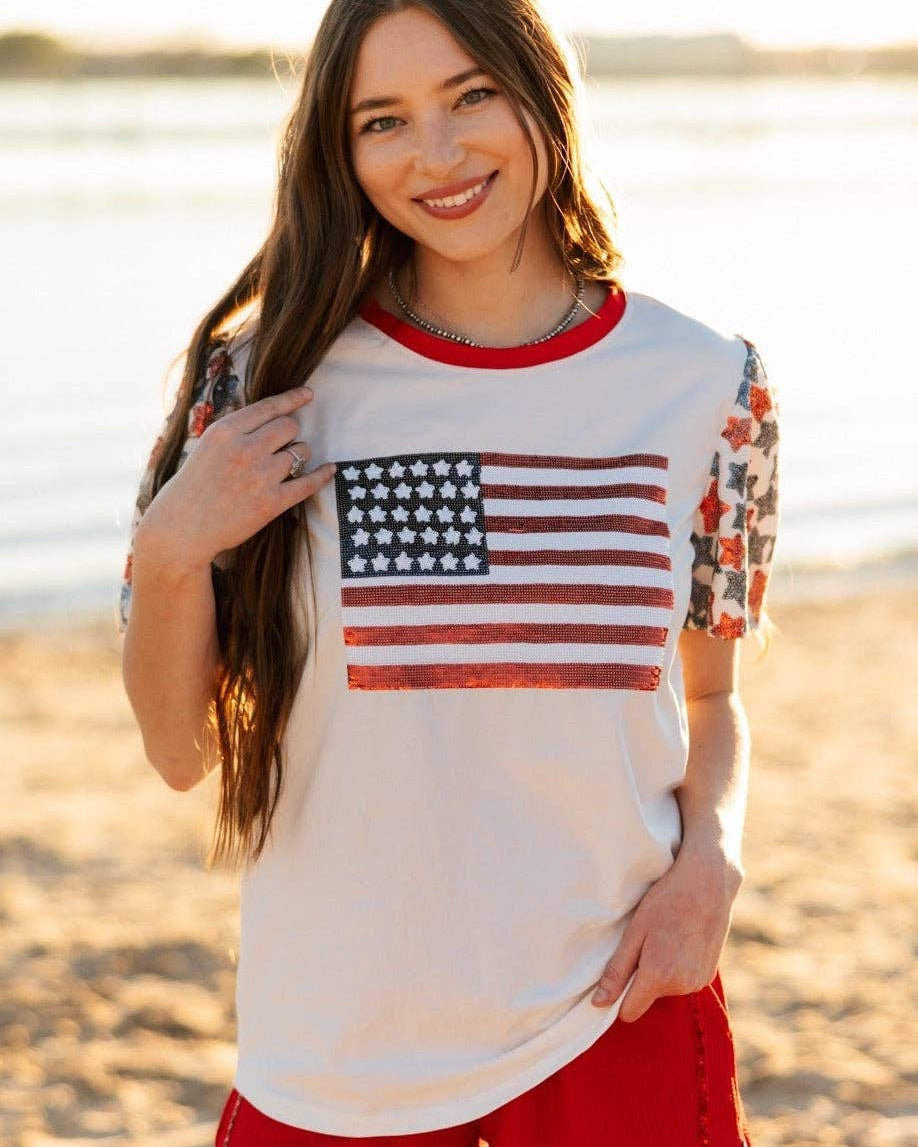 a high-stretch roomy-fit crew neck top with a sequin American flag front, lined star sleeves (red, white, and blue), red neckline trim, and a comfortable fit that runs large
