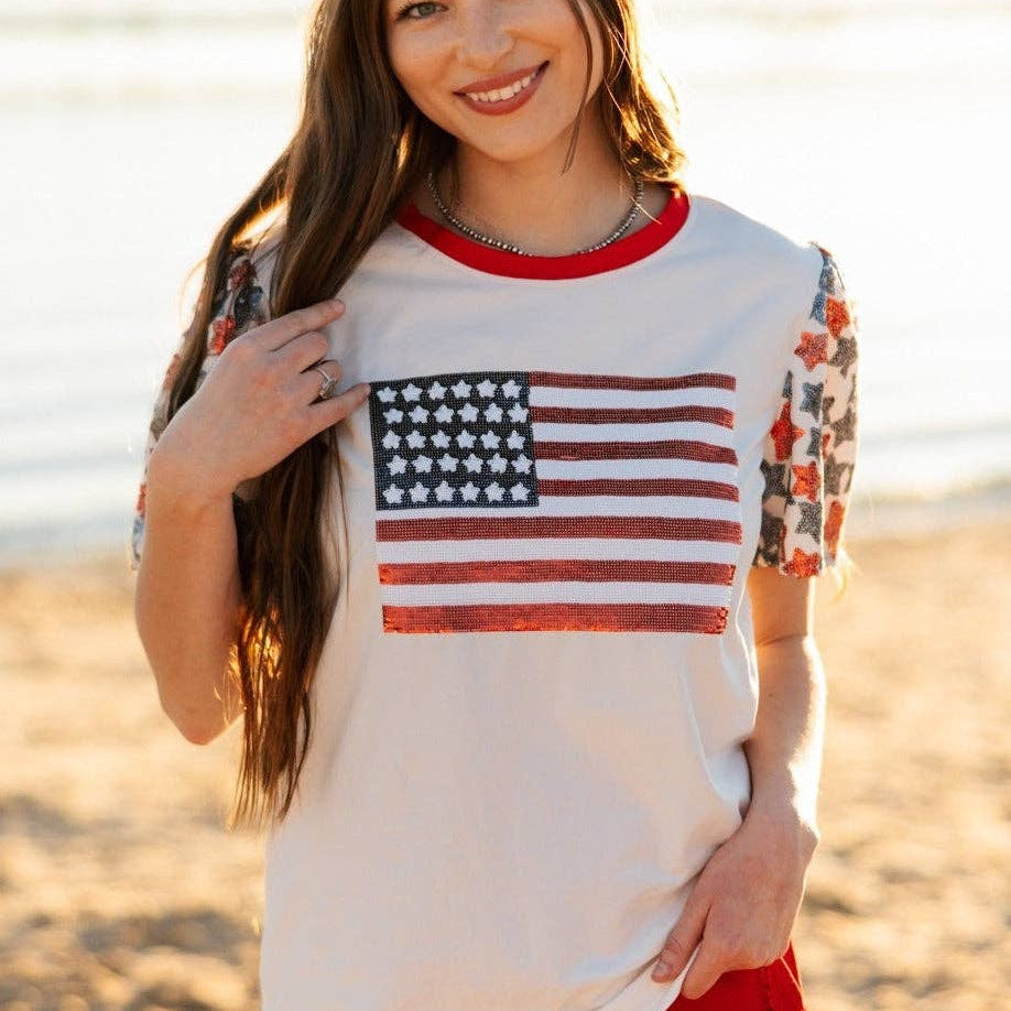 a high-stretch roomy-fit crew neck top with a sequin American flag front, lined star sleeves (red, white, and blue), red neckline trim, and a comfortable fit that runs large