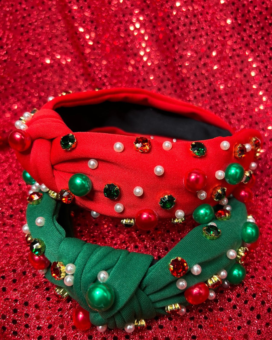 top knot adorned with jewel-tone beads, pearls, and rhinestones on velvet in green and red