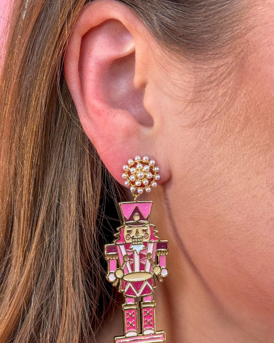 pearl cluster stud earrings paired with adorable dangling pink nutcrackers, finished in glossy gold-tone detail and gold comfort earring back
