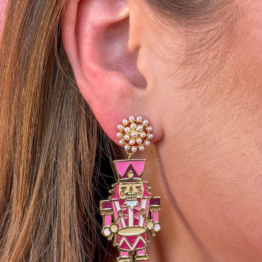 pearl cluster stud earrings paired with adorable dangling pink nutcrackers, finished in glossy gold-tone detail and gold comfort earring back