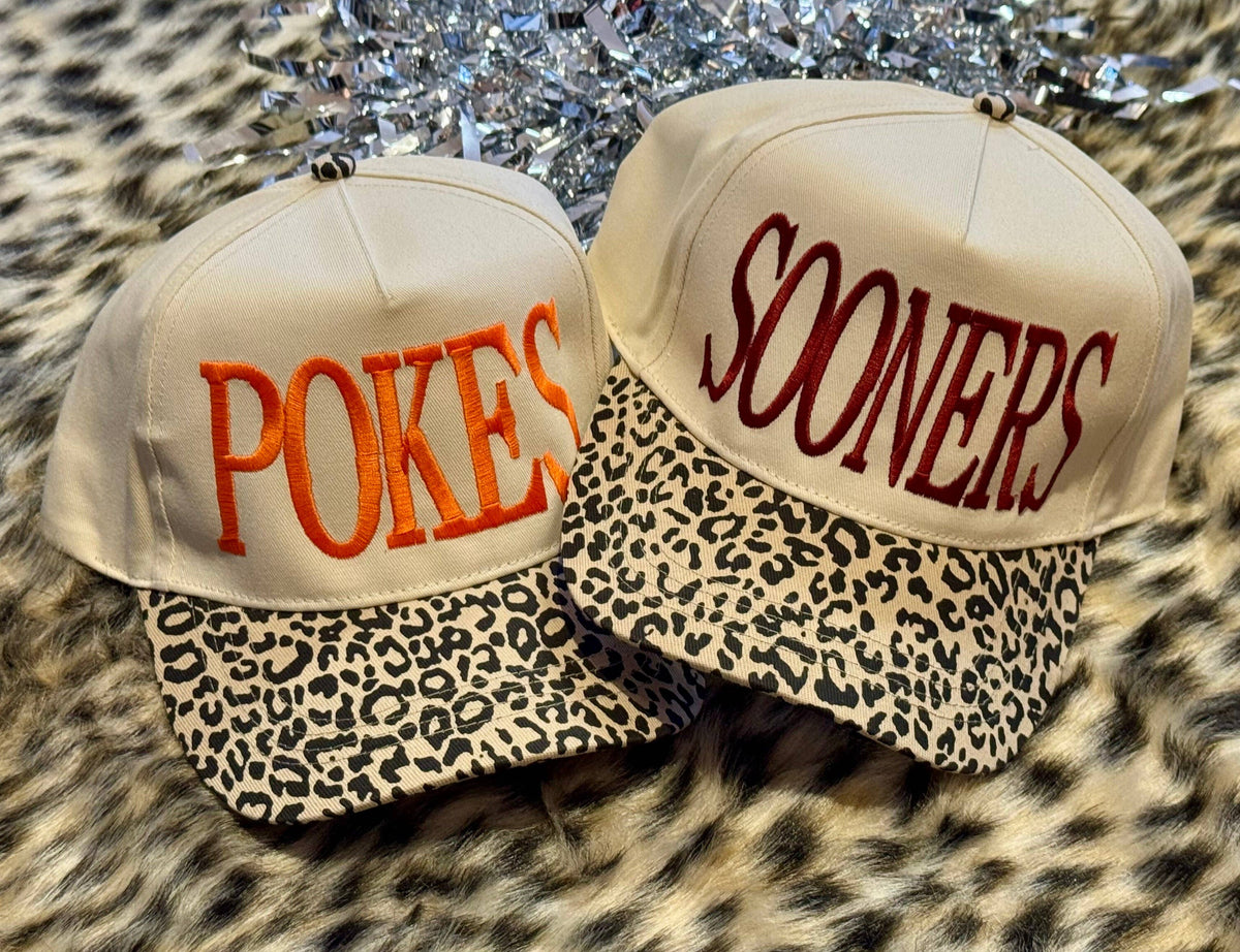 Two hats with 'POKES' and 'SOONERS' text on a leopard print background