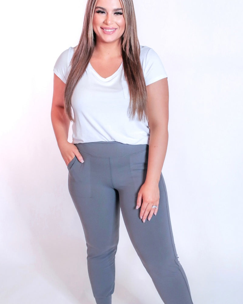 grey high-rise joggers crafted on smooth stretch fabric with a 3" waistband, side pockets, interior waistband back pocket, contoured back seam detail, tapered leg, and cuffed ankles