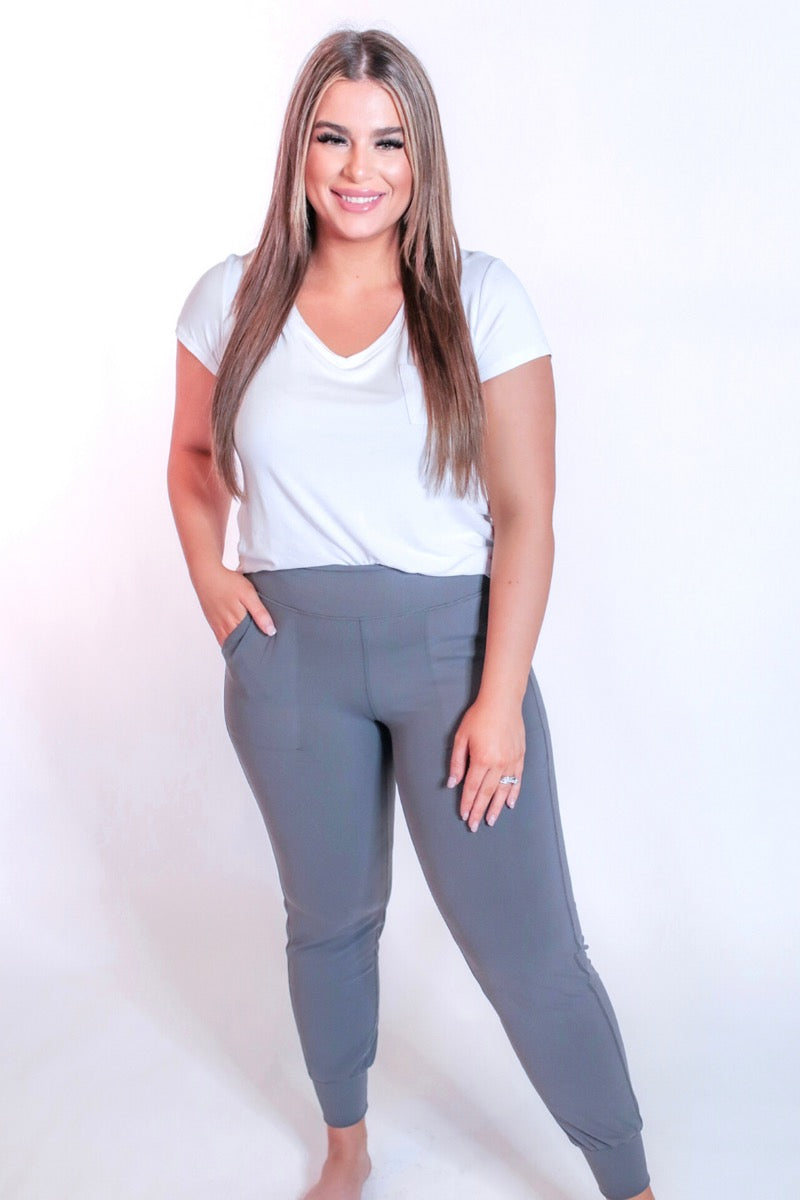 grey high-rise joggers crafted on smooth stretch fabric with a 3" waistband, side pockets, interior waistband back pocket, contoured back seam detail, tapered leg, and cuffed ankles
