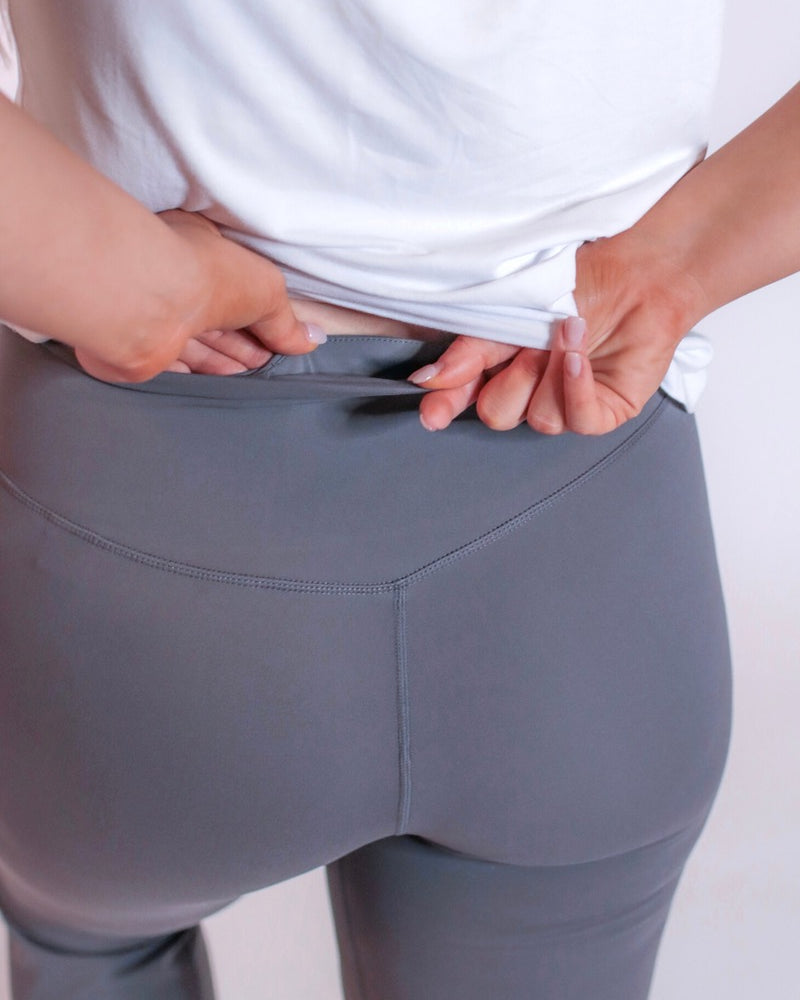 grey high-rise joggers crafted on smooth stretch fabric with a 3" waistband, side pockets, interior waistband back pocket, contoured back seam detail, tapered leg, and cuffed ankles