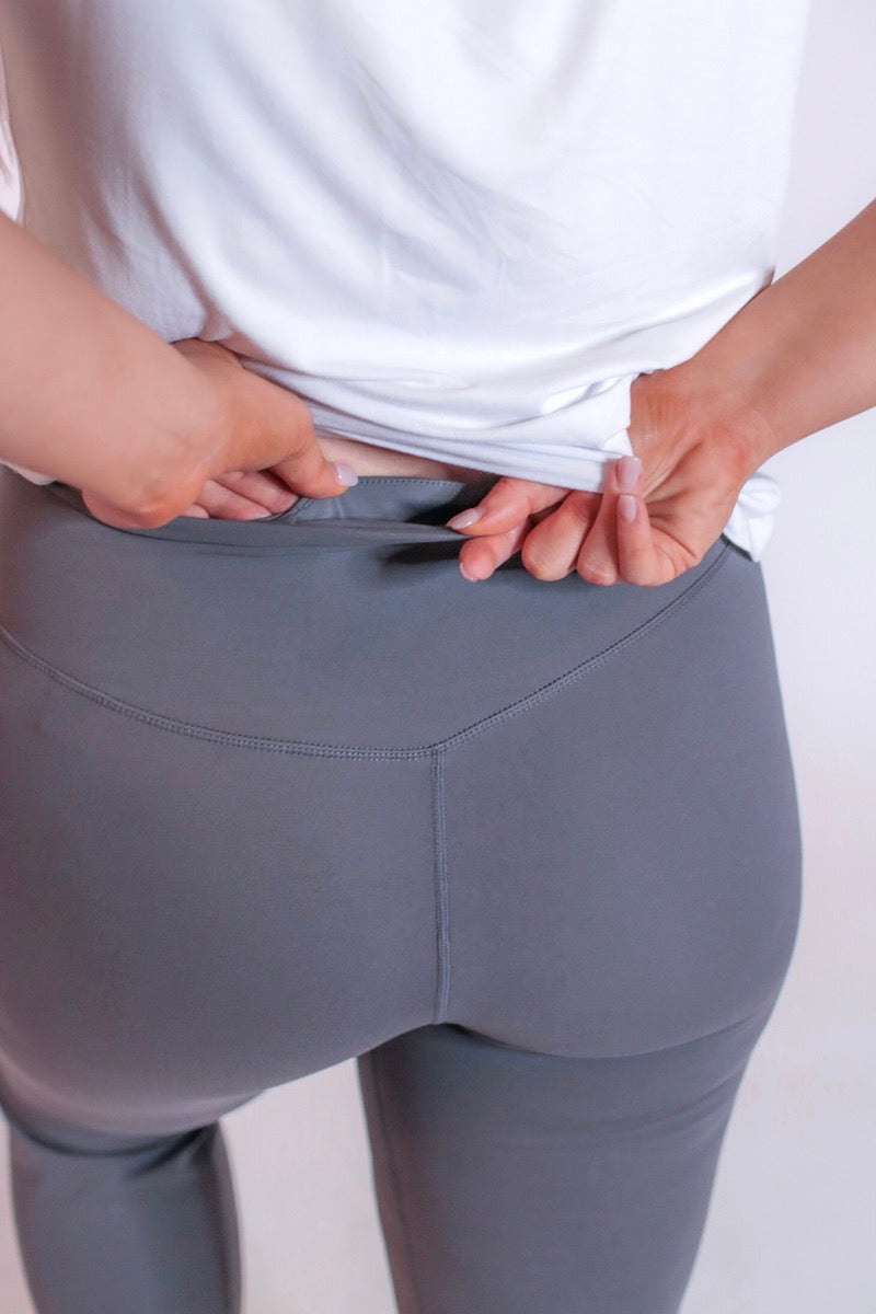 grey high-rise joggers crafted on smooth stretch fabric with a 3" waistband, side pockets, interior waistband back pocket, contoured back seam detail, tapered leg, and cuffed ankles